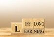 Lifelong learning symbol. Turned wooden cubes for concept words. Business, educational and lifelong learning concept.