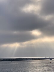 Wall Mural - Clouds and rays of sun over the sea