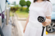 © DG PhotoStock - Unrecognizable Asian woman holding a DC - CCS type 2 EV charging connector at EV charging station.