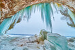 Large chunks of broken icicles at entrance to ice cave with hanging blue icicles
