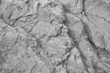 Black White Rock Texture. Cracked Layered Mountain Surface. Close-up. Gray Grungy Stone Background With Space For Design.