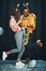 Canvas Print - She makes life way better. Full length shot of two attractive young women standing and hugging each other during a New Years party.