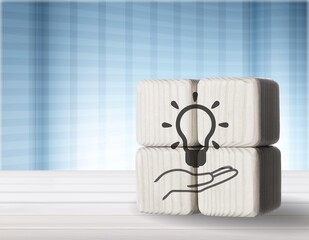 Sticker - Hand puts the wooden cubes with light bulb on hand icon. New idea concept.