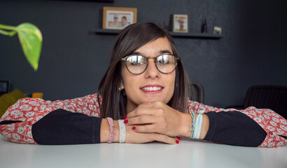 Wall Mural - smiling pretty brunette with eyeglasses, at home