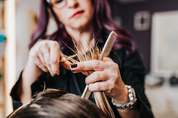 Wall Mural - Beautiful young woman getting her haircut by a hairstylist at a beauty salon.