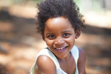 She Loves Playing In The Woods. Portrait Of An Adorable Little Girl Smiling At The Camera While Enjoying A Day Outdoors.
