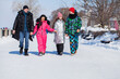 © Andrey_Arkusha - Young family of four walking outdoors in winter