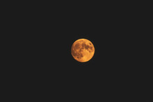 A Full Orange Moon In A Black Night Sky