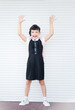 Vertical picture of 9 years old happy caucasian school girl on white background with hands up. Happy girl wants to learn. Smiling child in school uniform.
