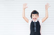 Horizontal portrait of 9 years old happy caucasian school girl on white background with hands up. Happy girl wants to learn. Smiling child in school uniform.