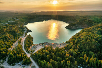 Lake and beach with beautiful blue turquoise water surrounded by green forest at golden sunrise. Aerial photography from a drone. Ukraine. concept, vacation, travel, nature and landscape