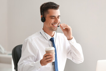 Poster - Male consultant of call center with coffee cup working in office