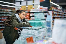 Pensive Supermarket Customer Feels Worried About Rising Product Prices In Supermarket.