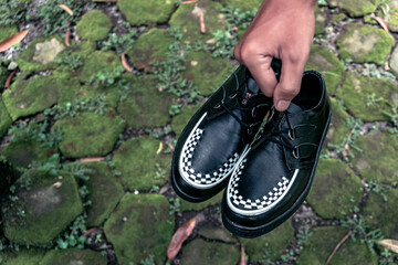 Wall Mural - These black creepers with black-and-white weave are made of leather and with a black sole, these elegant and luxurious sneakers are made by a home craftsman.