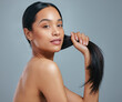 © Kirsten D/peopleimages.com - I always make sure to follow healthy hair habits. Studio portrait of an attractive young woman posing against a grey background.