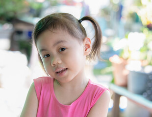 Wall Mural - Portrait of happy Asian girl with adorable ponytails smiling and looking at camera.