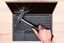 Hand Breaking Laptop Screen With A Hammer