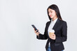 © Png - Video - Photo - Entrepreneur pretty woman holding coffee cup and touching screen on smart phone mobile on white background, attractive asian people drink beverage  smart, Technology communication lifestyles concept.