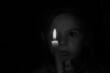 © Виктория Котлярчук - A little Ukrainian girl pray near a candle in the dark, a prayer to God for peace, religion