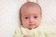 © dechevm - Adorable newborn baby.  Newborn child relaxing in bed and smiling. Happy newborn infant baby