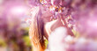 © Volodymyr - Young beautiful sexy carefree woman posing on the spring background. Summer model holding flowers in hands outdoors. Banner for header website design, copy space.