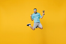 Full Body Young Fitness Trainer Instructor Sporty Man Sportsman In Headband Blue T-shirt Golded Medal Hold Winer Cup Jump High Isolated On Plain Yellow Background. Workout Sport Motivation Concept