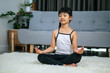 © Johnstocker - girl doing yoga in room on white carpet