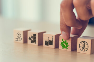 Wall Mural - Carbon footprint. Green business concept. Climate changing problems solving goals. Putting wooden cubes with carbon footprint icon standing with pollution source icons on smart background,copy space.