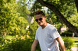 © Werner - Attractive fourty year old man with sunglasses and white T-shirt posing in the botanical garden