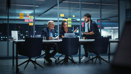 office conference room meeting: diverse team of top managers talk, brainstorm, use laptop computer. 