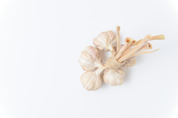 Five cloves of garlic tied with twine on a white background. Close up top view.