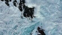 Slow Motion Shot Of Huge Ocean Wave Crashes On Rocks. Aerial Top Down View Of Sea Or Ocean Surf Splash. Stormy Weather With Strong Wind