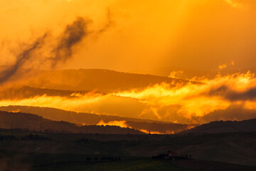 Wall Mural - Scenic sunset over rolling hills in silhouette