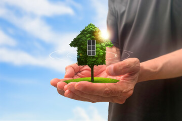 Hands holding green house. Fantastic with a house and small backyard in hands.