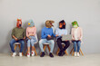 © Studio Romantic - People with animal faces sitting in line waiting for job interview. Applicants in funny silly masks reading CVs and resumes and using laptops. College or university students discussing test or exam