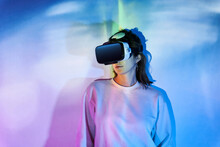 Woman In VR Headset Near Wall With Glowing Lights