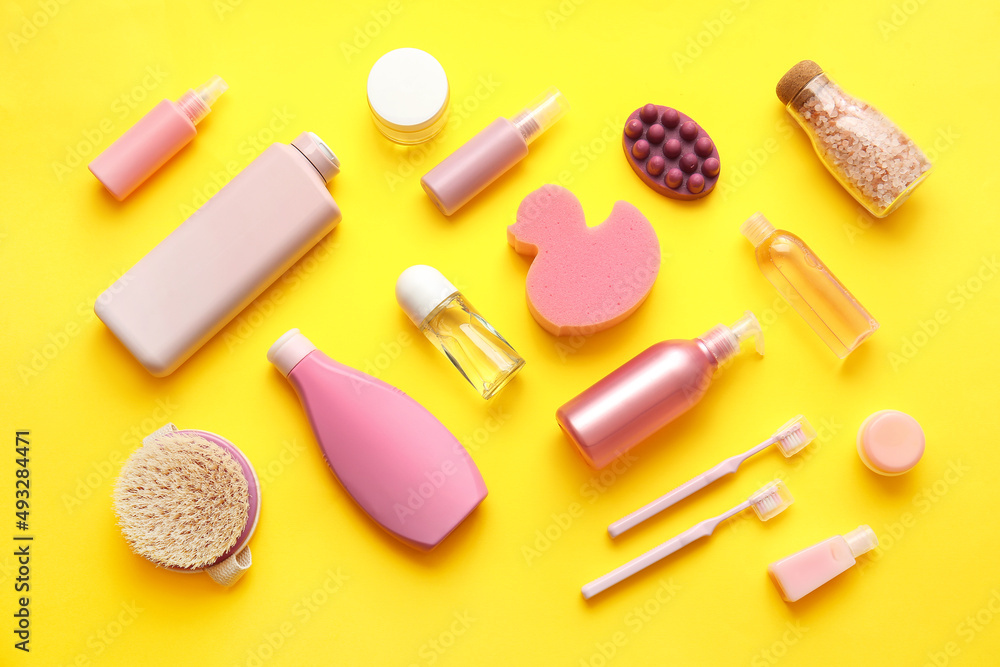 Composition with different cosmetic products and bath supplies on yellow background