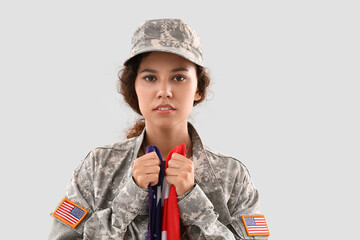 Wall Mural - African-American female soldier with USA flag on light background