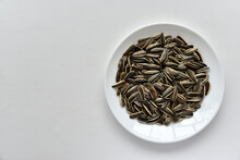 Striped Sunflower Seeds On A White Plate
