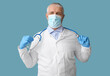 © Pixel-Shot - Mature male doctor in medical mask with stethoscope on blue background