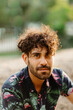 © Isabel Alcaine/Stocksy - Portrait of a young guy with a beard and a flamingo shirt.