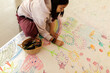 © Valentina Barreto/Stocksy - Girl drawing continuous paper on the floor