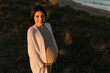 © Ezequiel Giménez/Stocksy - Positive pregnant Hispanic woman on beach