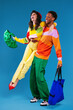 © BONNINSTUDIO/Stocksy - Content multiracial couple in colorful outfits