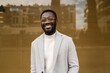 © Ezequiel Giménez/Stocksy - Cheerful elegant black male smiling at camera on street