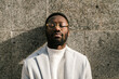 © Ezequiel Giménez/Stocksy - Black man leaning on wall on street with closed eyes