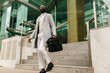 © Ezequiel Giménez/Stocksy - Black entrepreneur on stairs of office