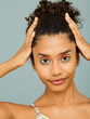 © ohlamour studio/Stocksy - smiling woman touching hair