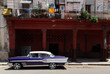 © Shava Cueva/Stocksy - a purple old car with white lines parking on the street
