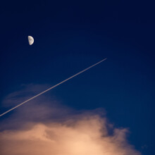 Airplane Ascending With The Moon In The Sky
